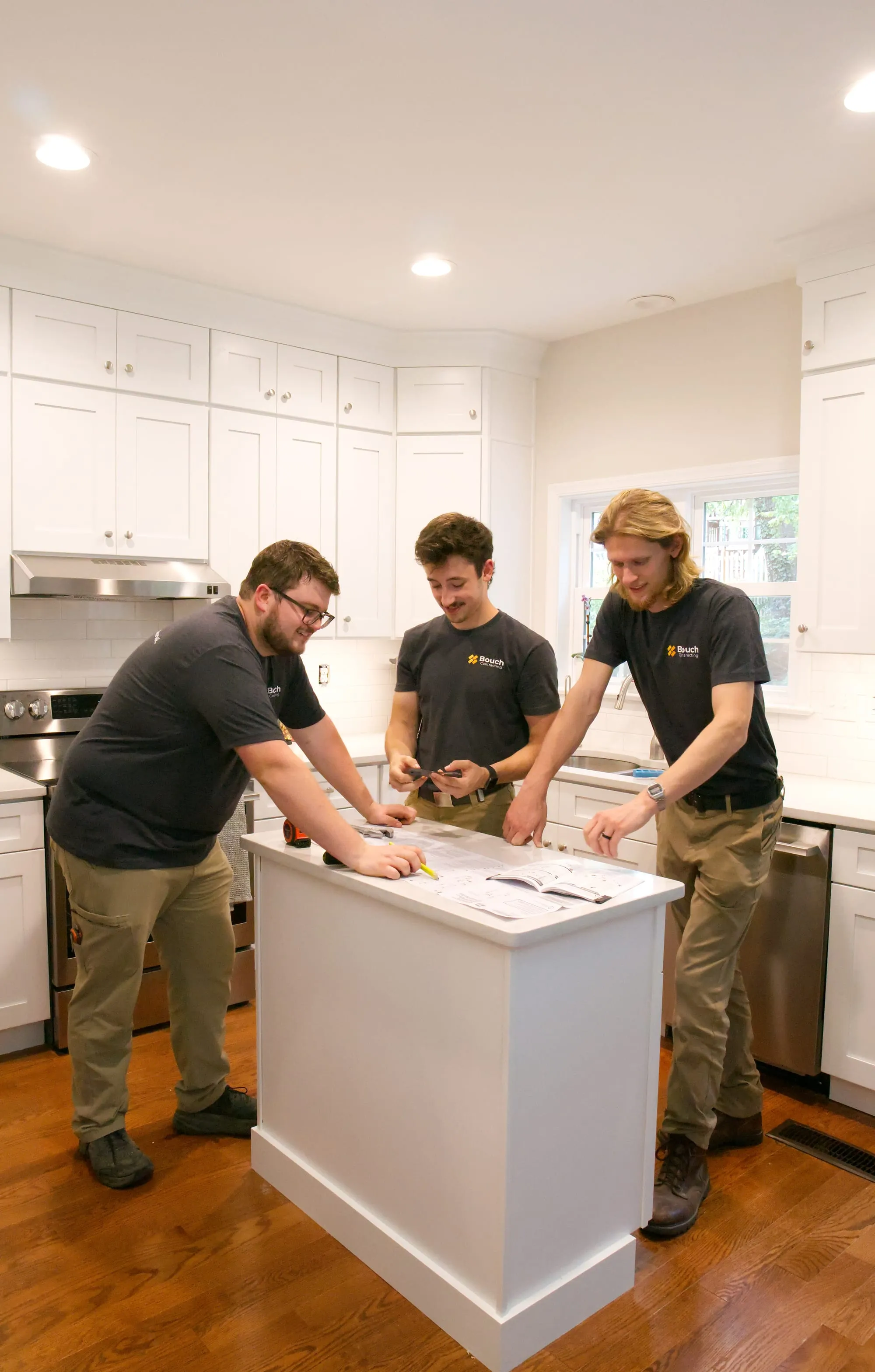 Harrison, Carson, and Joey going over plans at a kitchen island