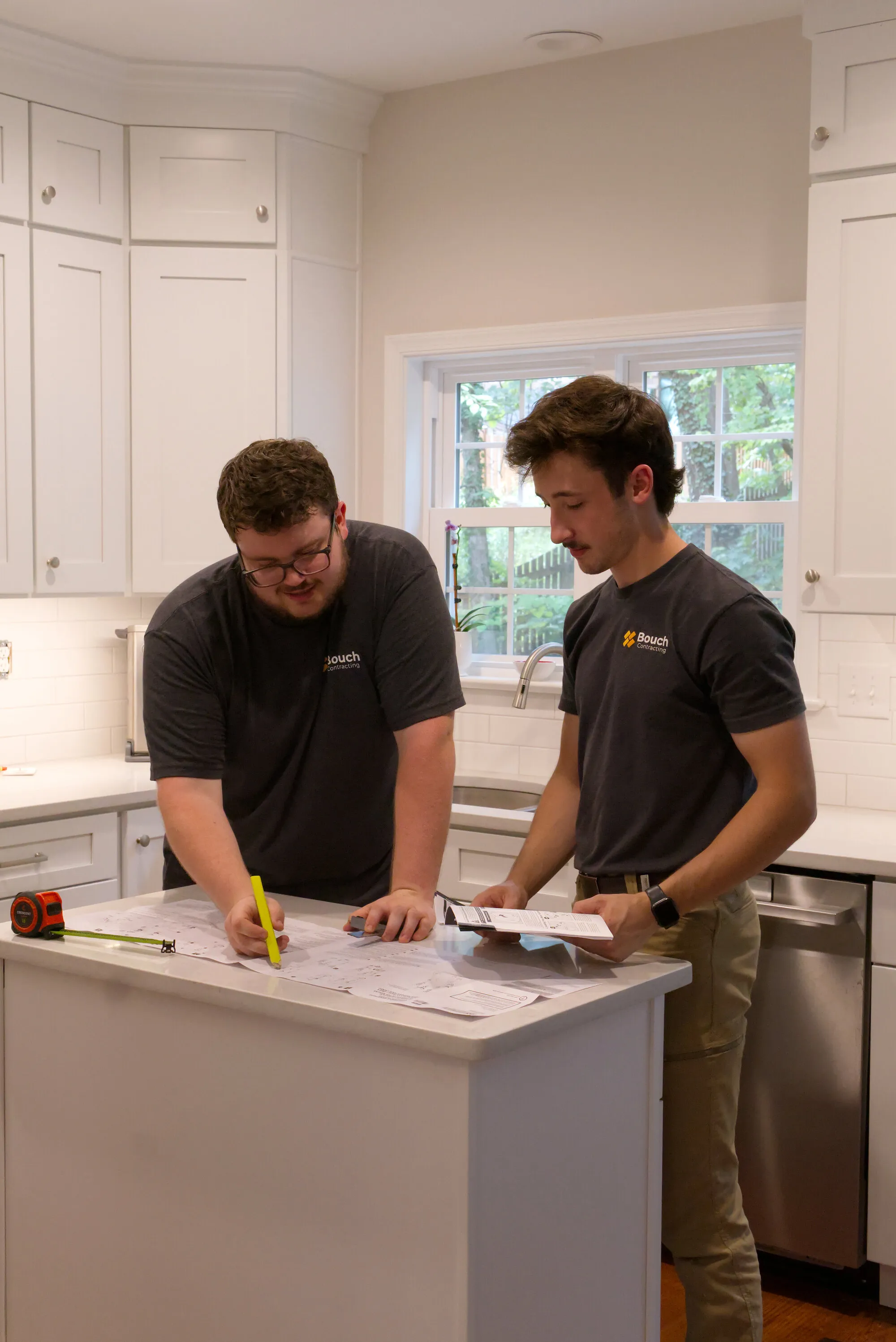 Harrison and Carson going over plans at a kitchen island